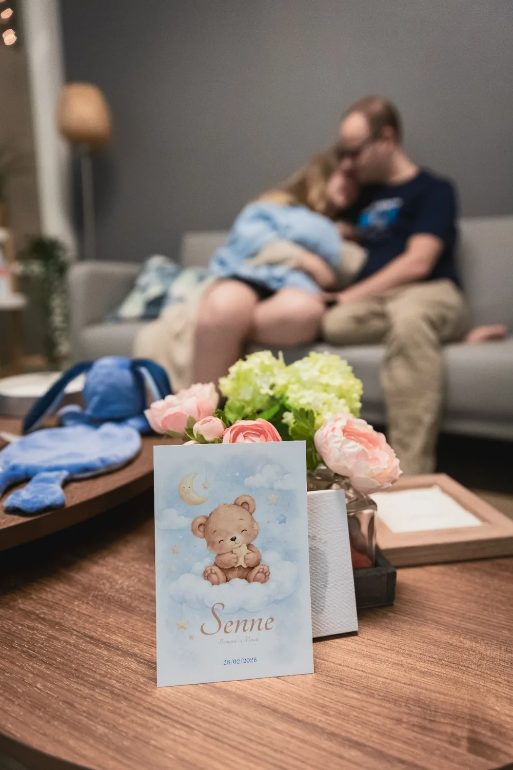 Geboortekaartje van Senne; op de achtergrond mama en papa met Senne in hun armen.